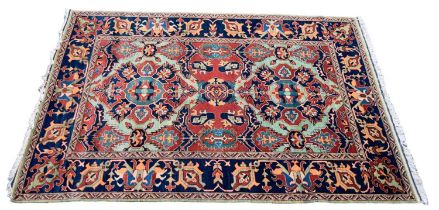 A Hamadan designed rug with allover medallion set central red ground panel within a stylised blue