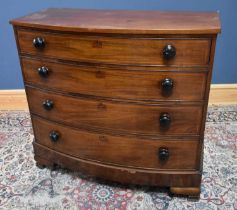 A 19th century inlaid mahogany bowfronted chest of four drawers on bracket feet, with turned