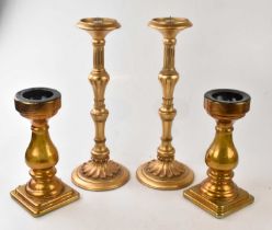 A pair of gilt candle holders, height 48cm, and a similar pair of amber glass examples (4).