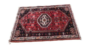 An Eastern style rug with stylised decoration, on predominantly red ground, 163 x 116cm.