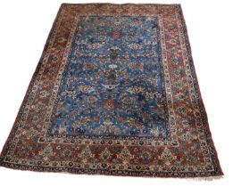 A Persian wool rug, worked with an allover floral pattern against a blue ground, 220 x 147cm.