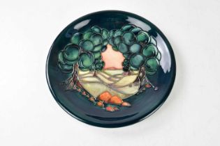 MOORCROFT; a modern plate decorated with a landscape scene (seconds quality), diameter 26cm.