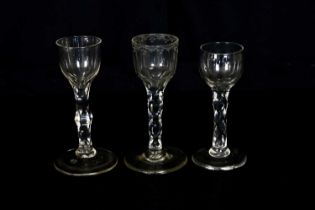 Three 19th century wine glasses with faceted stems including an example with etched rim, height 14cm