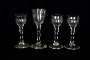 Four 19th century and later wine glasses with faceted stems, including a near pair with ogee