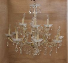 A cut glass electrolier with eight lower scrolling branches with dish sconces beneath four upper
