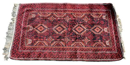 A Tekke designed red ground rug with lozenge shaped medallions, 175 x 106cm.