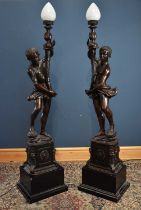 A pair of large and decorative bronzed metal Blackamoor type figural lamps on square plinth,
