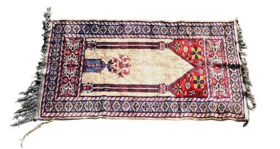 A small Caucasian rug with central medallion on a beige and red ground with stylised border, 123 x