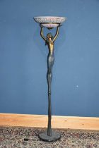 A decorative bronze effect figural standard lamp with circular ceramic shade modelled as a semi nude