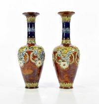 DOULTON LAMBETH; a pair of Artware vases with flared necks, relief decorated with floral detail,