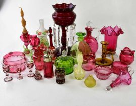 A collection of cranberry glass and other coloured glass to include jugs, vases, lustre, candle