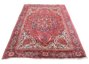 A Caucasian handwoven wool carpet, worked with a central medallion and an allover floral design