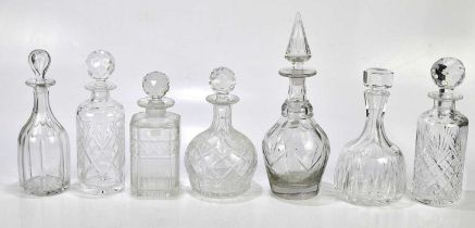 A collection of seven cut glass decanters, largest 34cm.