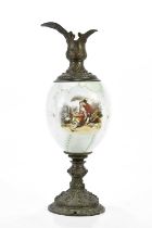 A late Victorian bronzed spelter and opaque glass vessel printed with figures in a landscape, height