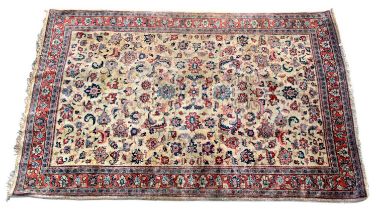 A Persian designed rug with detailed floral motifs on a cream ground within a stepped border, 183