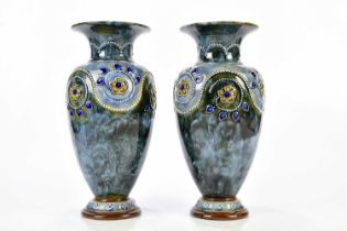 ROYAL DOULTON; a pair of Artware vases with flared necks, with tube lined and relief decoration of