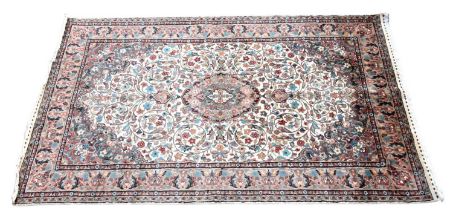 An Indian designed rug with allover floral motifs set on a beige ground with stylised border, 255