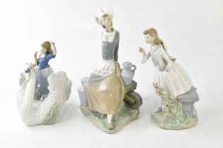 LLADRO; three large figures including a girl holding flowers, height 30cm, a Dutch girl seated on