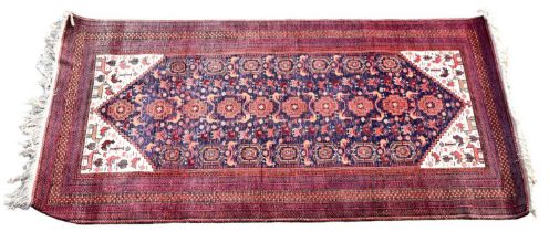 A Hamadan designed rug with multi device set lozenges to the main panel and with multi stepped red