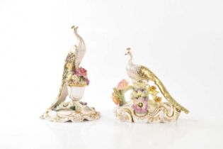 ROYAL CROWN DERBY; two hand painted porcelain models of peacocks with floral encrusted decoration,