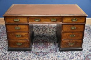 A 19th century teak campaign kneehole desk, with replacement leather insert above an arrangement
