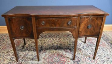 An Edwardian serpentine front mahogany sideboard with single drawer flanked by panelled cupboard