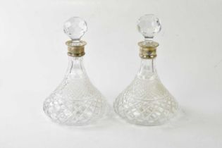 A pair of cut glass hallmarked silver collared decanters, height 28cm.