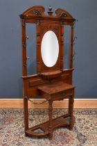 A Victorian carved walnut hall stand, with central bevelled plate above single drawer flanked by