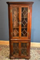 A 19th century Georgian mahogany freestanding corner cupboard with moulded cornice above two pairs