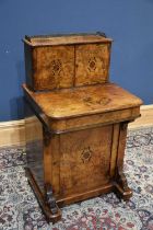 A Victorian burr walnut Davenport with raised back, the back section with brass gallery and two