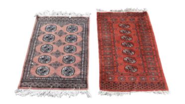 A red ground Eastern style rug with elephant foot decoration to the centre, together with further