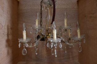 A cut glass electrolier with eight lower scrolling arms supporting dish sconces beneath four similar