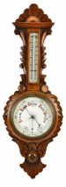 An early 20th century carved oak aneroid barometer.