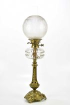 A Victorian oil lamp with etched glass shade above the cut glass reservoir and brass base, with