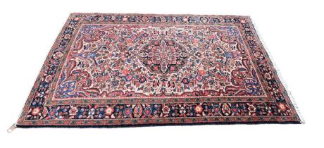 An Eastern style blue ground rug with floral and geometric pattern to the centre, 203 x 146cm.