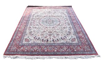 A large part silk Eastern style rug, with stylised floral decoration on a red and ivory ground,