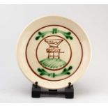 † GEOFFREY FULLER (1936-2022); a slip decorated earthenware plate depicting a pot on a potter's