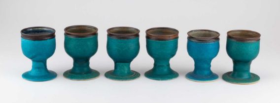 † ABDO NAGI (1941-2001); a set of six stoneware goblets covered in turquoise glaze with bronze rims,