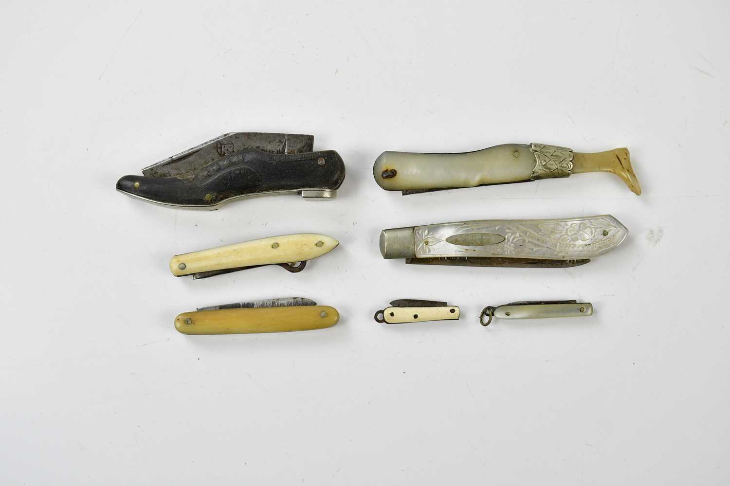 Seven fruit and miniature knives, including a mother of pearl cased example, modelled as a lady's