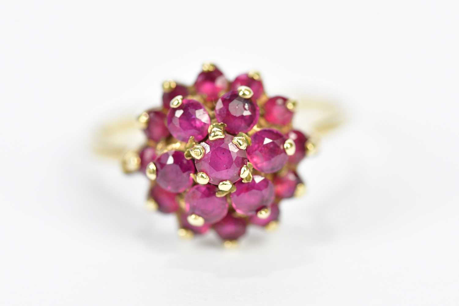 A 9ct yellow gold dress ring, set with a melee of red stones, size N 1/2, approximate weight 3.5g.