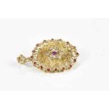 A yellow metal diamond and ruby combination pendant/brooch, with pierced design and fixed bail,