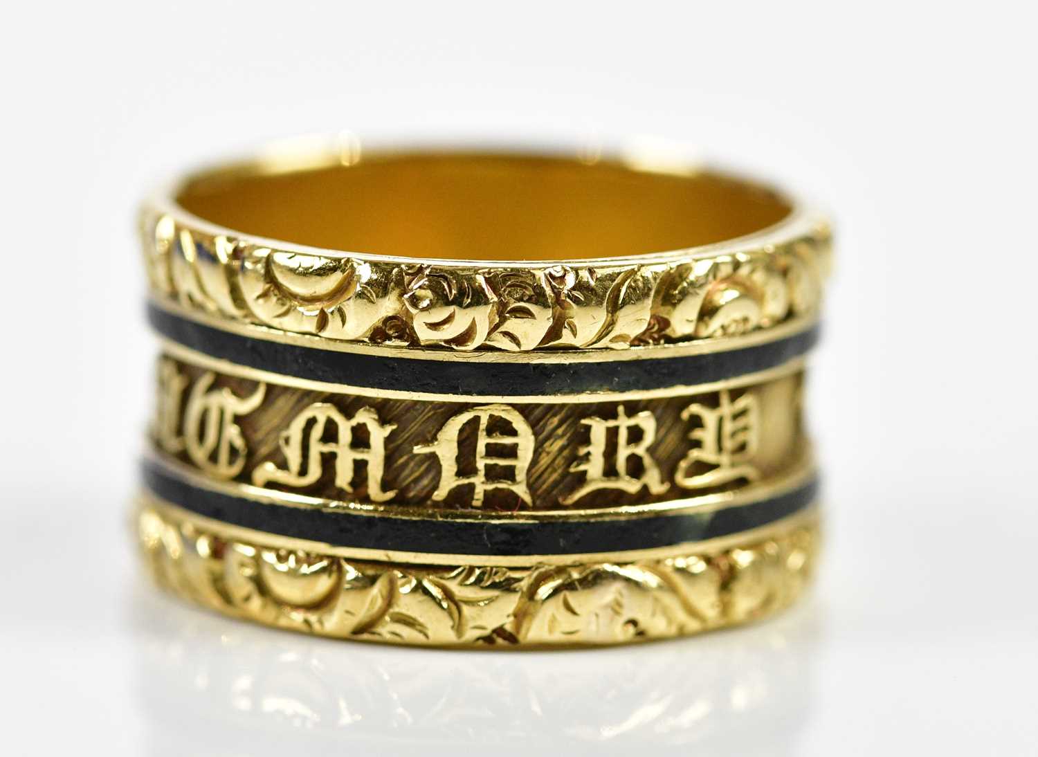 An 18ct yellow gold black enamelled mourning ring, the outer band inscribed 'In Memory Of', the