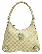 GUCCI; a monogram canvas GG D-ring shoulder bag trimmed with gold leather, with gold tone hardware