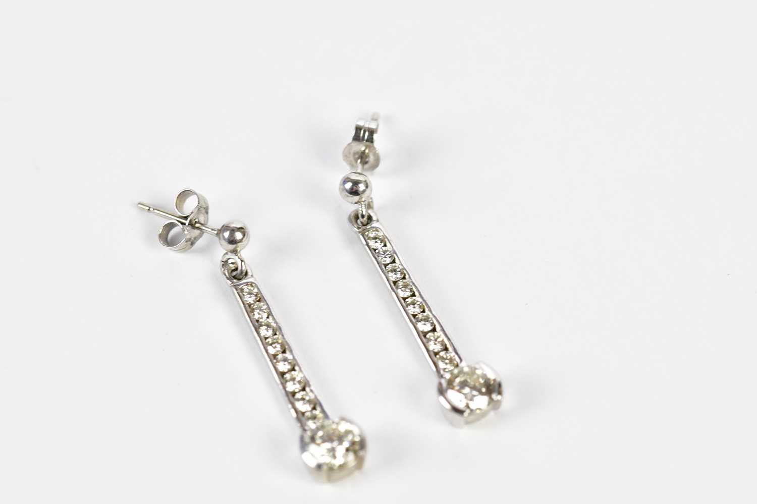 A pair of 18ct white gold diamond drop earrings, the channels set with eight tapering round - Image 3 of 4