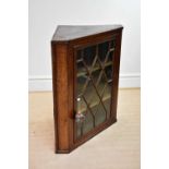 An 18th century oak and pine hanging corner cupboard with astragal glazed door, height 105cm,