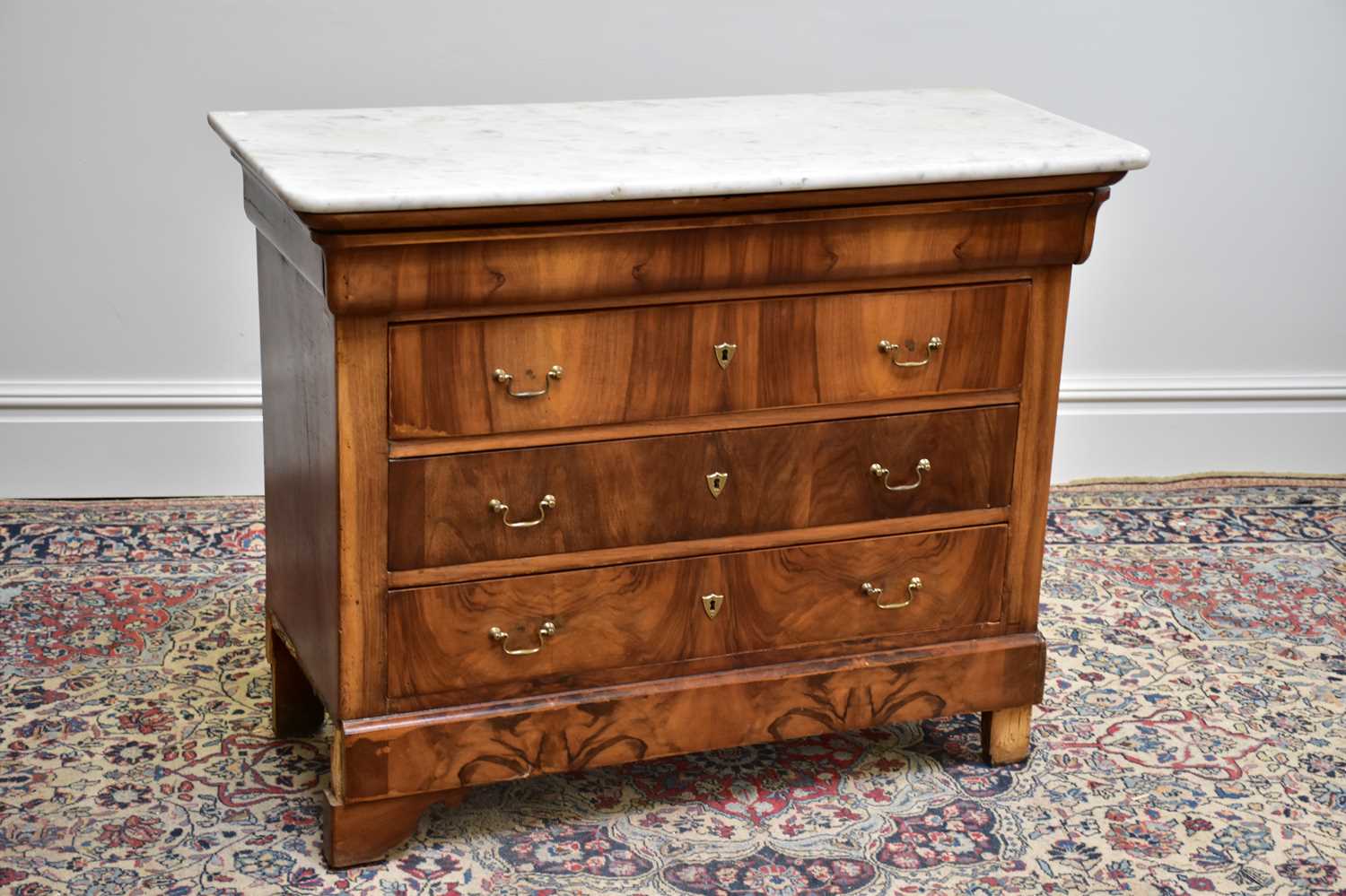 A French walnut marble topped chest of three drawers on bracket feet, width 115cm, depth 50cm,