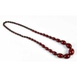 A vintage cherry amber coloured graduated bead necklace, length 68cm, approx 87g, the largest bead