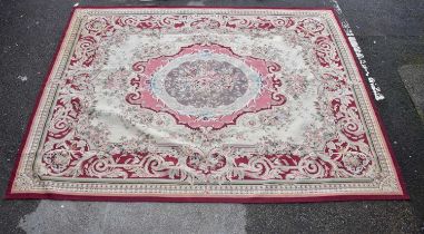 An Aubusson style hand woven carpet, worked with a central floral medallion with a pink ground,