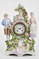 An early 20th century Continental porcelain figural mantel clock representing two maidens and a male