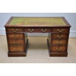 An Edwardian mahogany knee-hole twin pedestal desk with leather inset top above an arrangement of